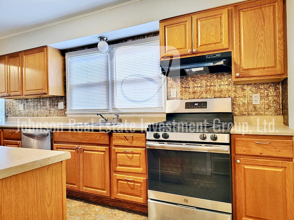 Large kitchen with lots of stainless steel gas range.
