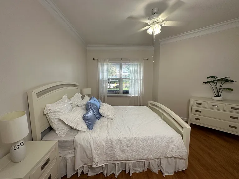 Bright and airy bedroom with elegant white bed linens, cozy pillows, and a stylish ceiling fan. Bright and airy bedroom with elegant white bed linens, cozy pillows, and a stylish ceiling fan.