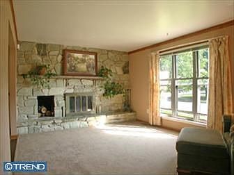 Family room with stone fireplace. Newly carpeted but has hardwood underneath