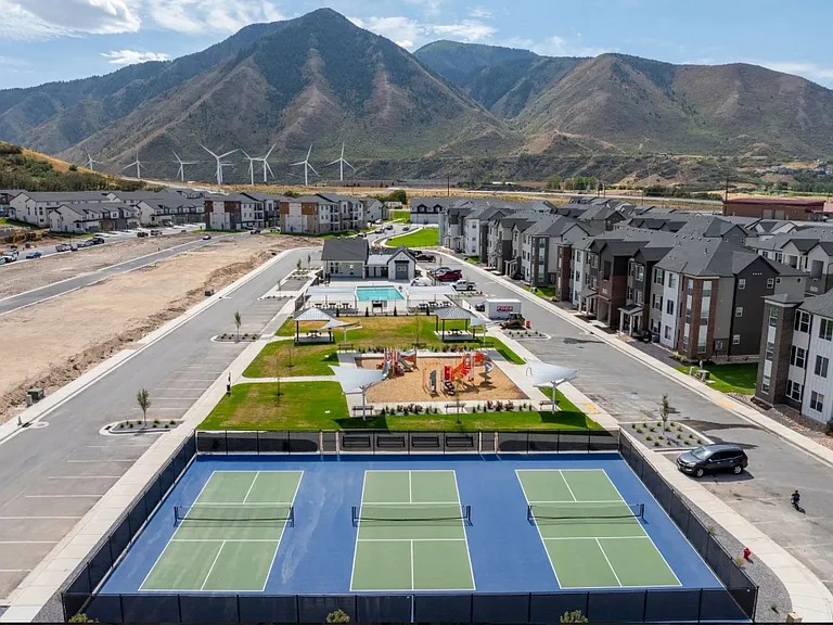 Aerial view of pickleball courts playground, pool, and clubhouse.