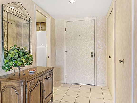 The welcoming foyer of unit #102 has an easy care tile floor and a roomy guest closet plus spectacul