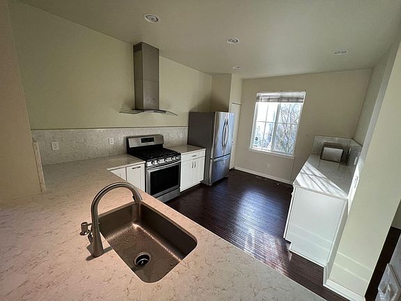 Updated kitchen with white cabinets, granite countertops and stainless steel appliances