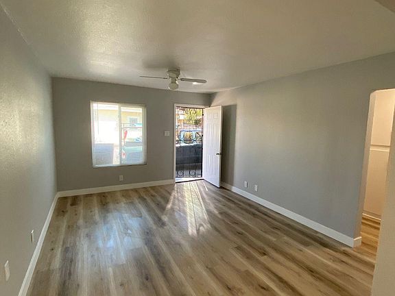 Living room shot from dining area. Fairly new floors, paint, doors, ceiling fan and baseboards