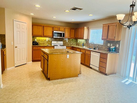 Kitchen features a spacious center island, large walk-in pantry for ample storage, and a bright breakfast area with room for an informal dining table_perfect for casual meals and entertaining.