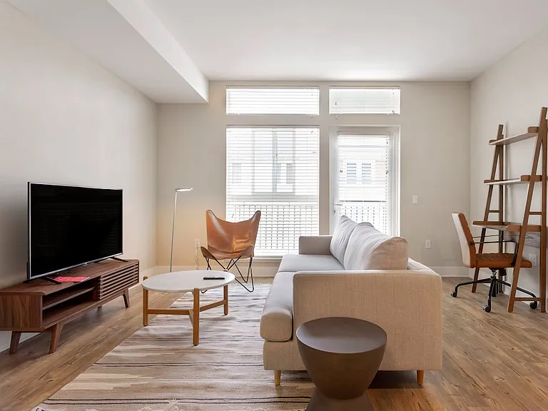 Furnished+ apartment homes come outfitted with a sofa, side chair, side table, coffee table, office chair, desk, TV stand and 50" Television (Representative Image exact items and style of furnishings may vary)