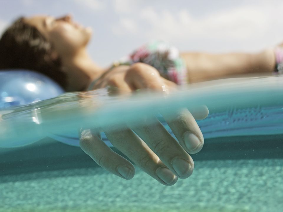 The rooftop pool, designed in a resort-style, features comfortable daybeds and shaded areas for relaxation.