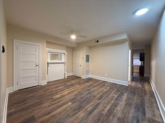 Open-concept living area featuring a decorative mantle and modern flooring.