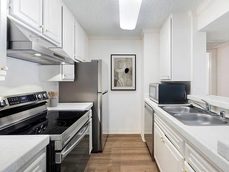 Classic Package II kitchen with white tile countertops, white cabinetry, stainless steel appliances, and hard surface flooring