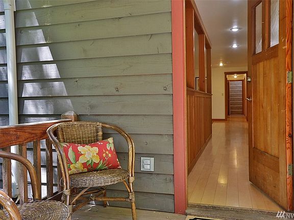 Main covered entrance, east side of home. Maple hardwood floors greet you at the door, lovely contrast to the custom fir finishes throughout the home. Take off your shoes and get a good sock slide going down the hallway!