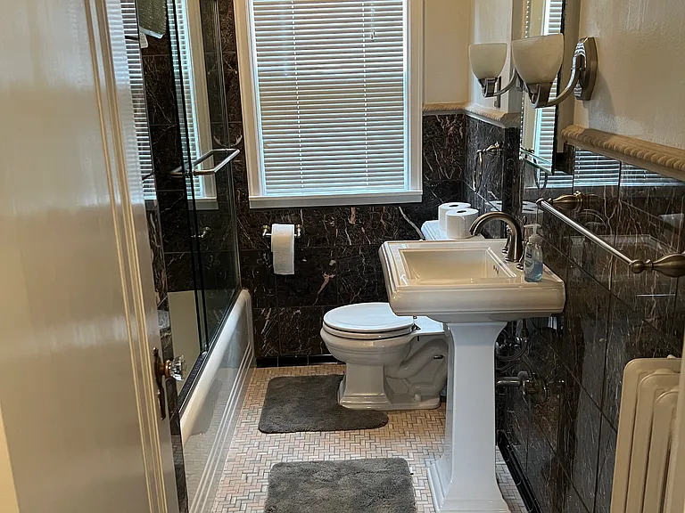 The bathroom has a bath and shower