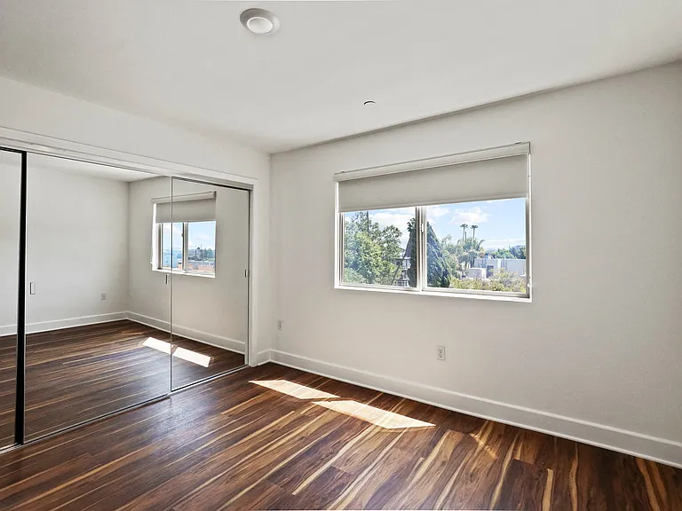 Bedroom with Vinyl Flooring, Mirrored Closet, and Vinyl Flooring