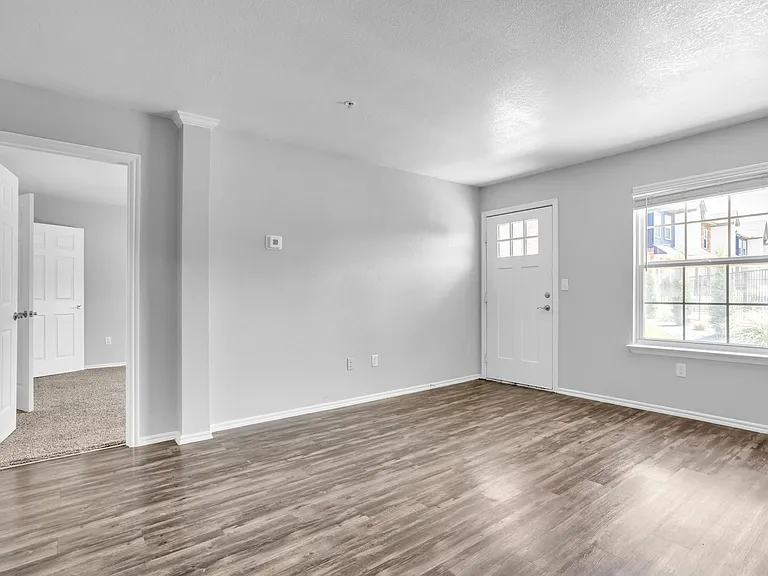 Bright and airy living space with elegant flooring and large window for natural light. Bright and airy living space with elegant flooring and large window for natural light.