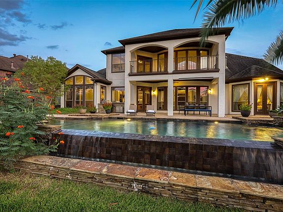 Exquisite infinity pool flanked by lush landscaping.