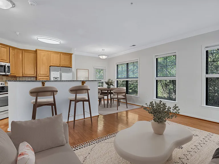 A modern kitchen with wooden cabinets and a dining area with a table and chairs.