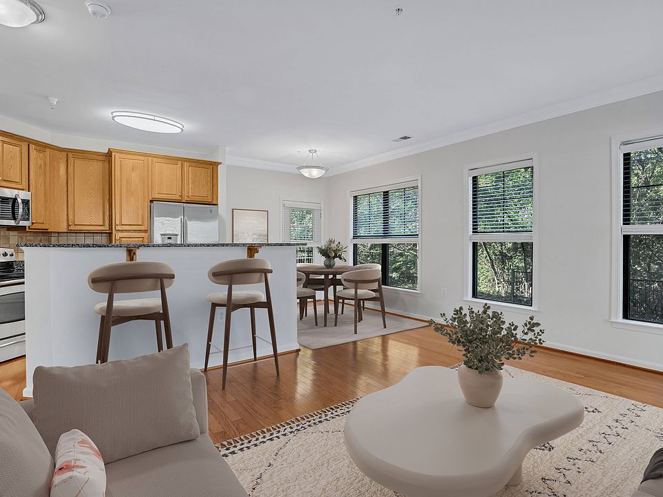 A modern kitchen with wooden cabinets and a dining area with a table and chairs.
