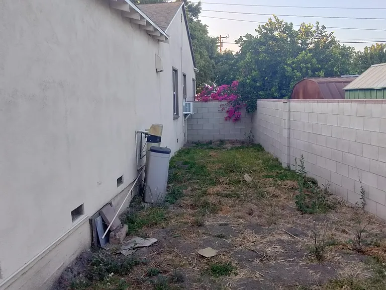 This is the side yard adjacent to the East Bedroom and the Living Room a/c unit. This area is also being improved currently