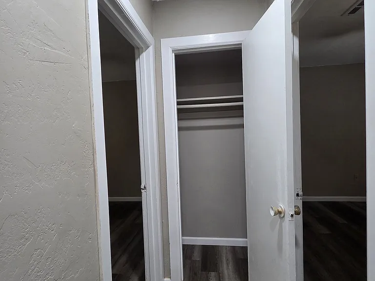Hallway coat closet with view to the bedrooms