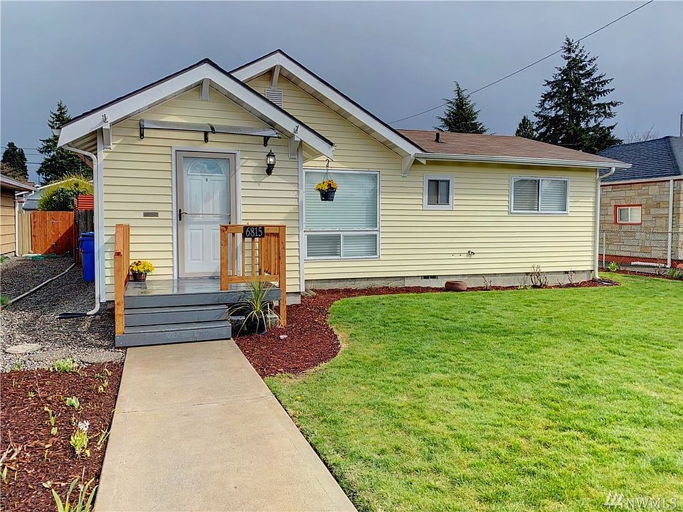 Freshly planted flowers lead you to this picture perfect rambler. Welcome home!