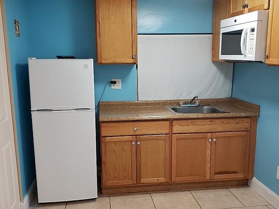 Kitchenette with fridge, microwave, and sink