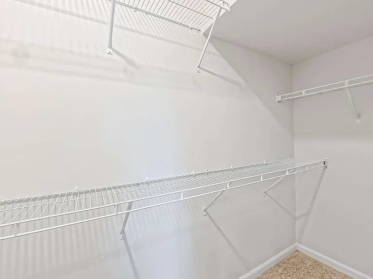 Bright, spacious closet featuring sleek white wire shelving for optimal storage solutions.