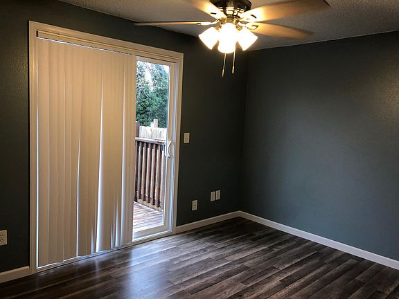First bedroom with fan and access to back patio and walk in closet