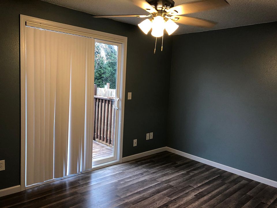 First bedroom with fan and access to back patio and walk in closet