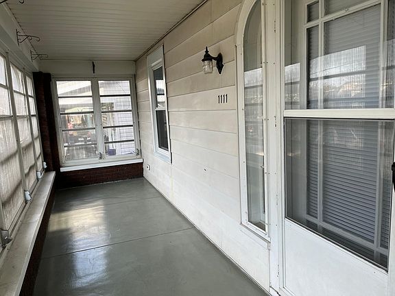 Enclosed front porch with crank windows and screens