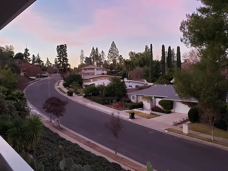 Neighborhood view from wrap around glass balcony overseeing neighborhood.