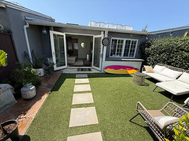 Large private yard leading to French doors and flagstone area to the left great for a BBQ