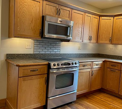 Kitchen with hardwood floors ,stainless appliances ,beautful wood cabinets ,upper and lower cabinet lighting