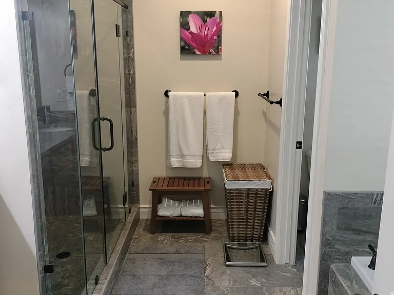 Spacious master bathroom with double sinks, a glass shower, and a large deep tub_perfect for relaxing after a long day. Designed for comfort and style, this serene retreat offers the ultimate in convenience and luxury.