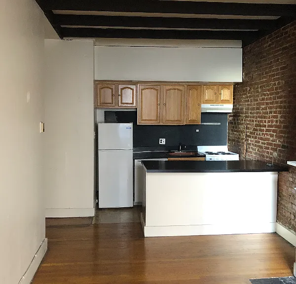 Kitchen with fridge, stove, dishwasher, garbage disposal in large sink, and extra storage space under island counter.