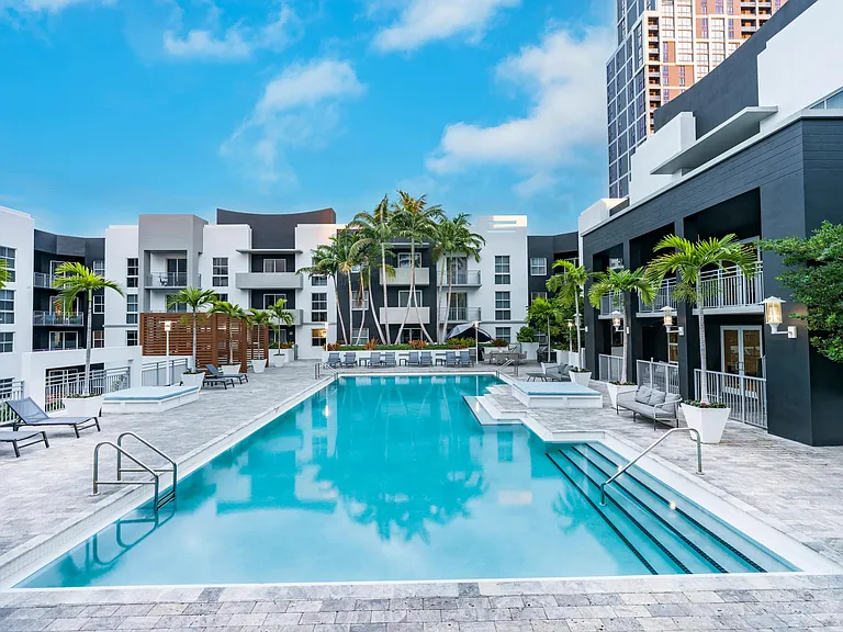 Modera Douglas Station offers a resort-style pool with bungalows, chaise loungers, and palm trees for ultimate relaxation.