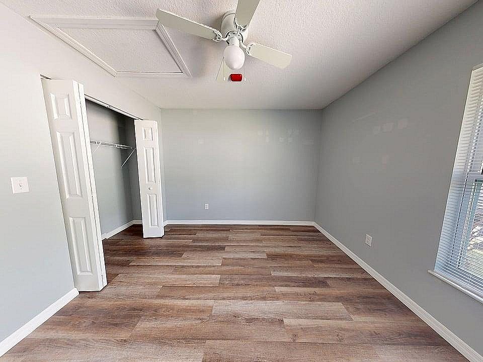 Bright, spacious bedroom with sleek hardwood floors, generous closet space, and abundant natural light from large windows.