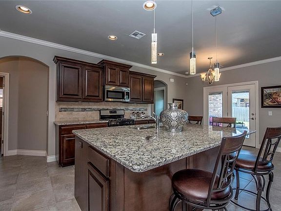 The gourmet kitchen features a gas cook top, built-in microwave, and a expansive granite island to entertain your family or guests.