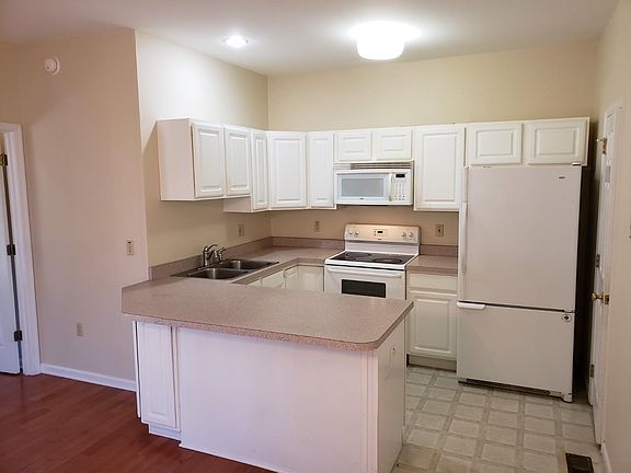 Kitchen with dishwasher, microwave over electric stove, and spacious fridge with ice maker. Half bath off kitchen