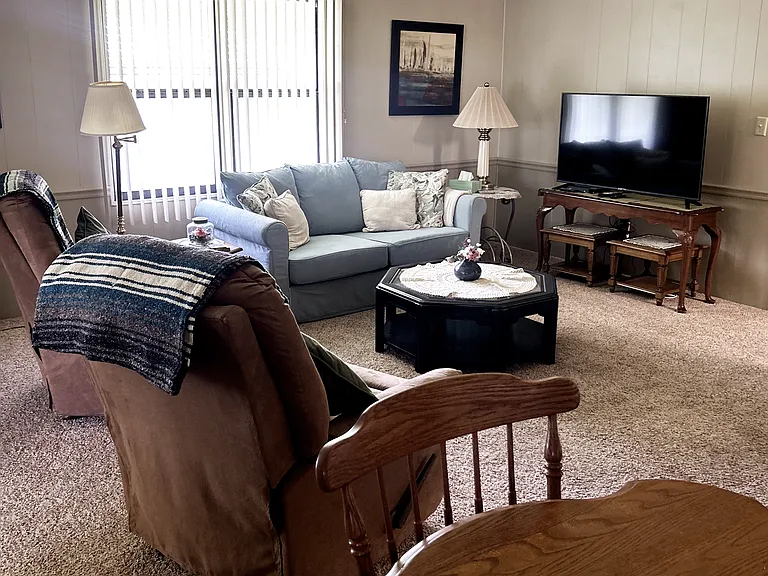 Large family room with pull out couch and 2 lazy Boy recliners.