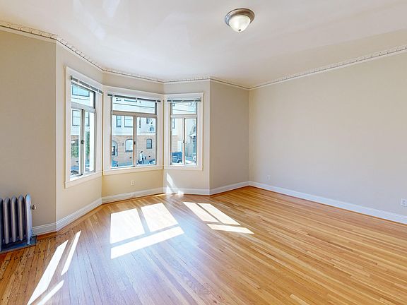 Bright bedroom with a large window and a wood-like floors
