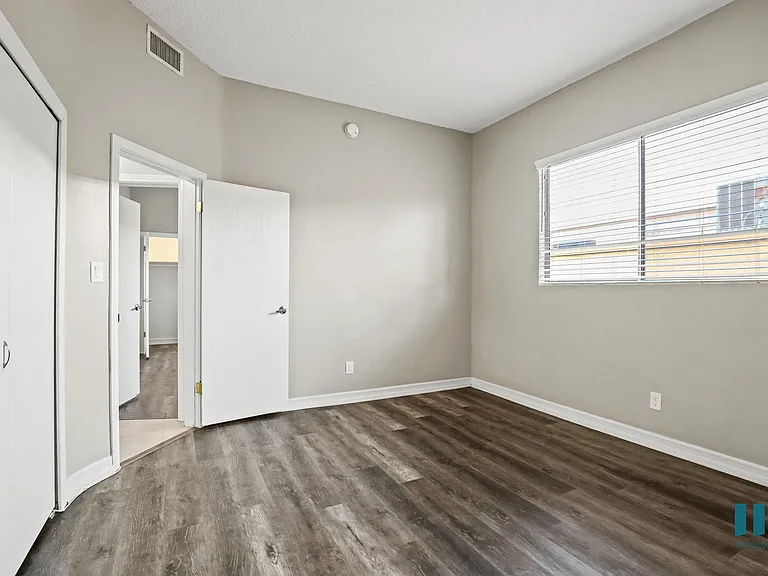 Bedroom with Large Windows, Closet, and Vinyl Flooring