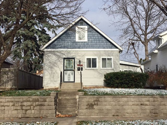 This is the front photo of the home. There is now a secured yard with a brand new 6.5' white vinyl privacy fence that is securable.
