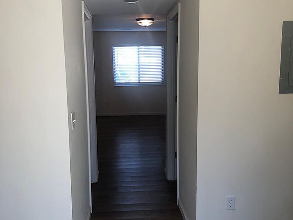 HALLWAY FROM LIVING ROOM INTO KITCHEN, LAUNDRY ROOM ON LEFT SIDE OF PICTURE AND HALF BATH ON RIGHT SIDE OF PICTURE