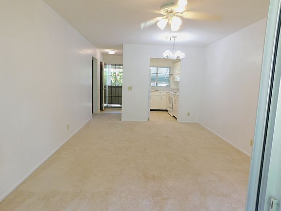 From the lanai through the living and dining area to the kitchen and entry with security screen door for added ventilation. Ceiling fan