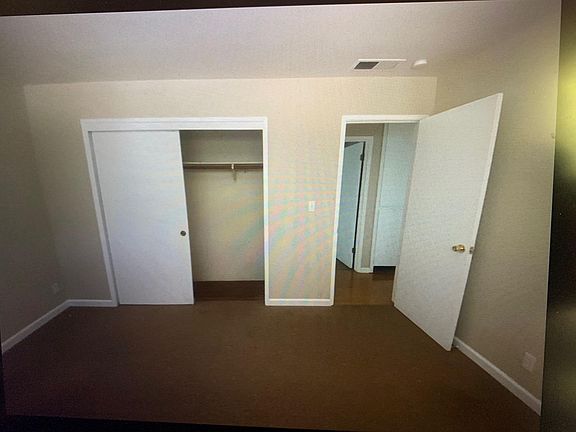 Smaller bedroom that looks out backyard. No neighbors in view.