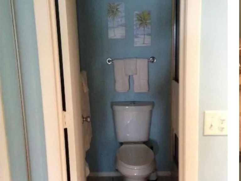 The full shower is right of the toilet. The shower has two bench seats. The large walk in closet is on the left with storage cabinet.