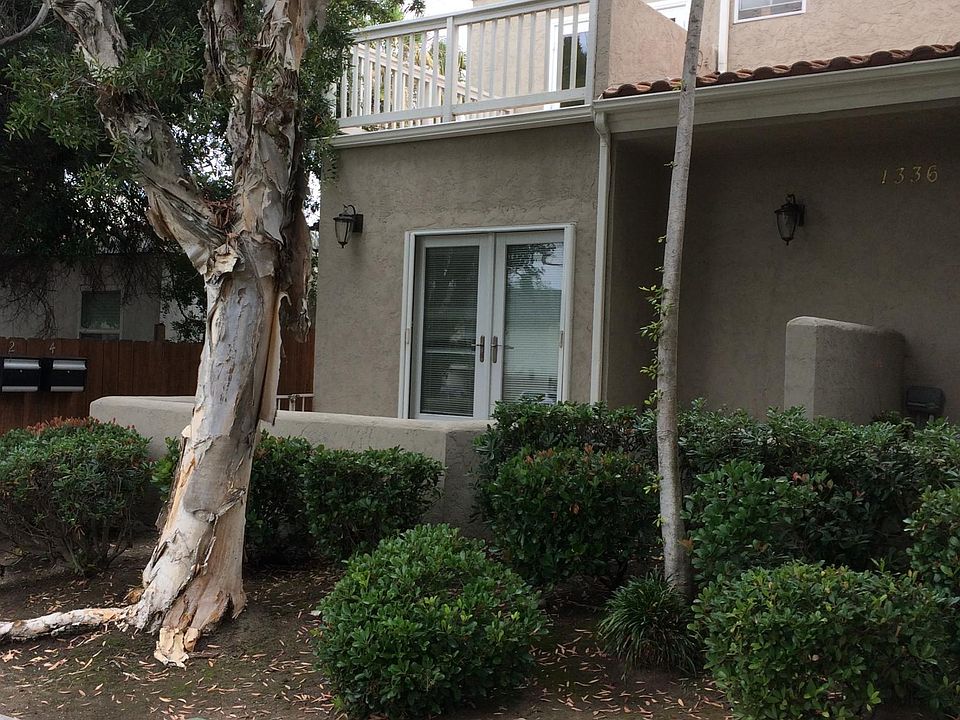 view from street of front patio and balcony off upstairs bedroom