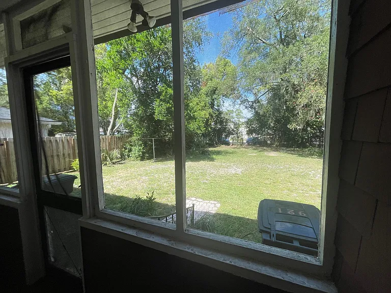 View out the back porch into the backyard (the parking area).