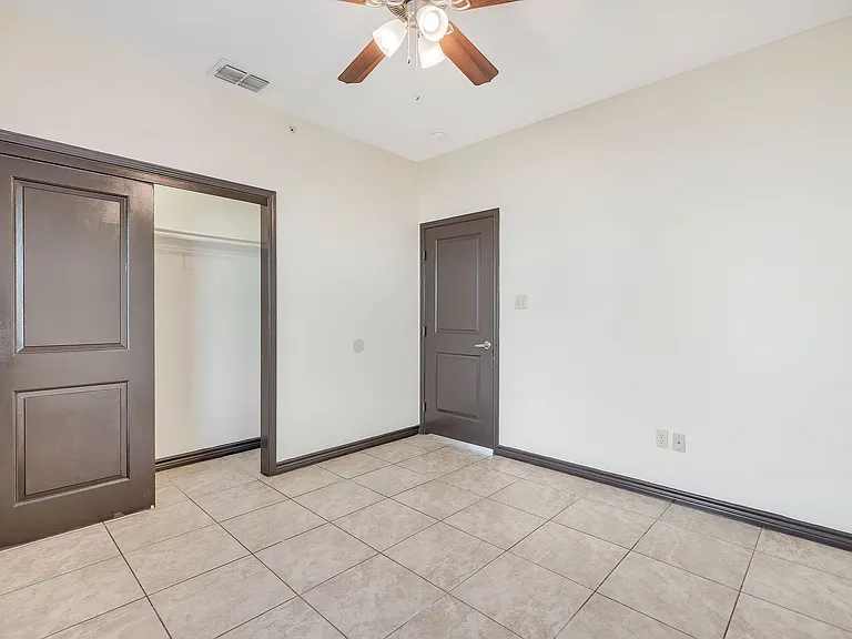 Unoccupied room in La Joya Apartments, Laredo, Texas, with a ceiling fan and a smooth tile floor