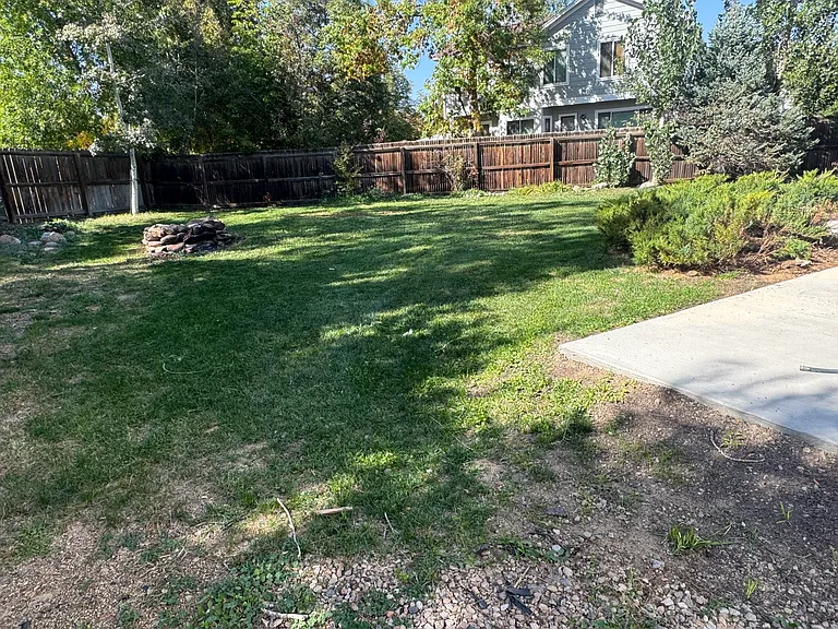 Large fenced backyard with firepit.