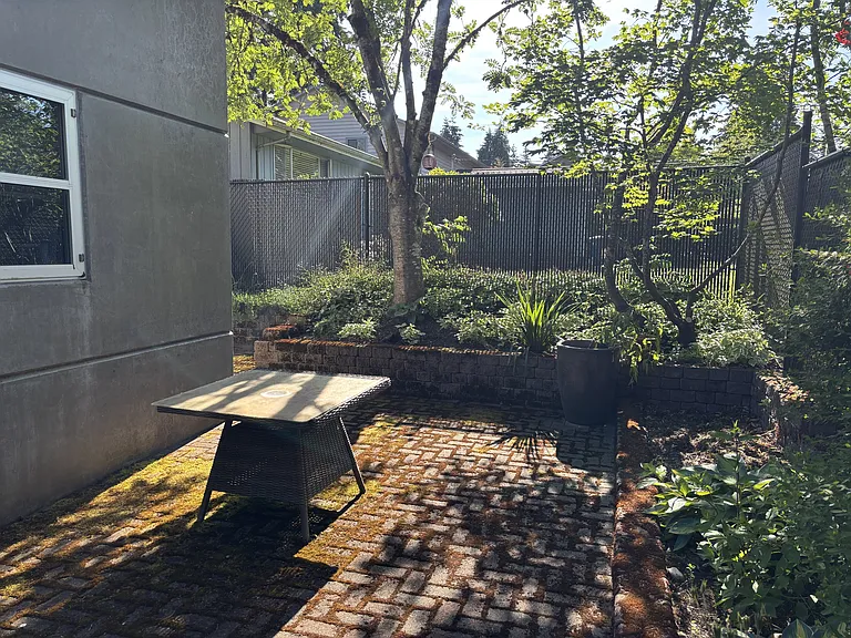 Trees, shrubs, flowers, and ground cover fill the raised brick beds surrounding the back patio spaces. Plenty of light in the winter and shade/sun combinations in the summer.