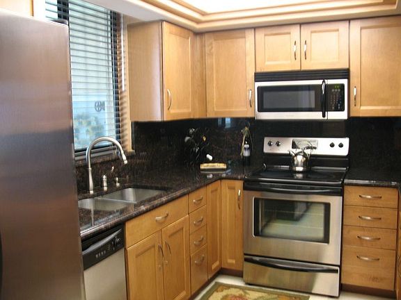 Kitchen has stainless steel appliances, ice & water in the door, marble flooring.